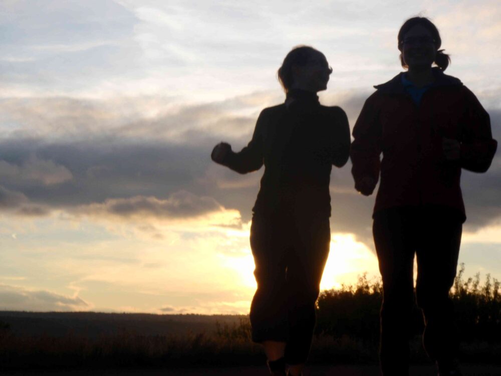 Two people jogging at sunset.
