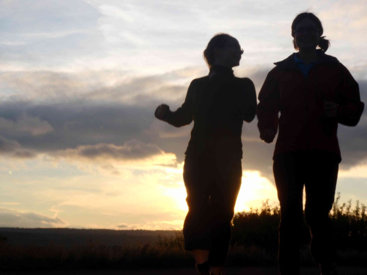 Two people jogging at sunset.