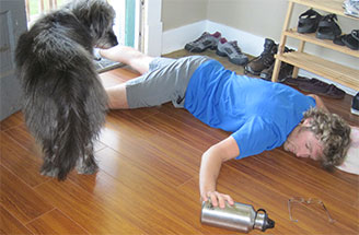 A man laying on the floor next to a dog.