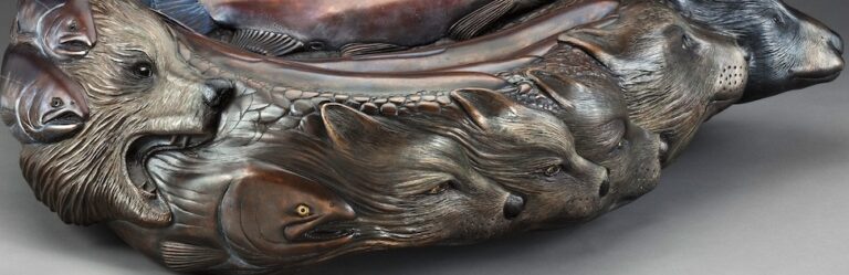 A sculpture of a fish on a gray surface.