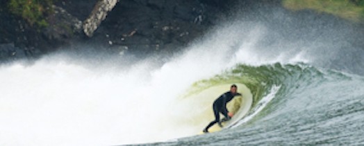 A man in a wetsuit riding a wave.