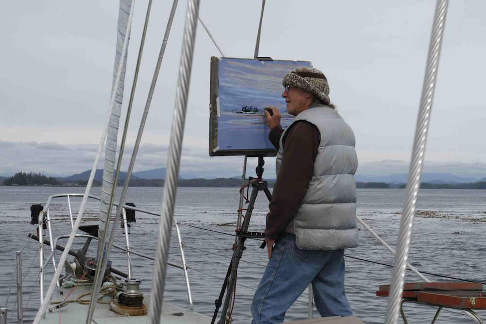 A man painting on a sailboat.