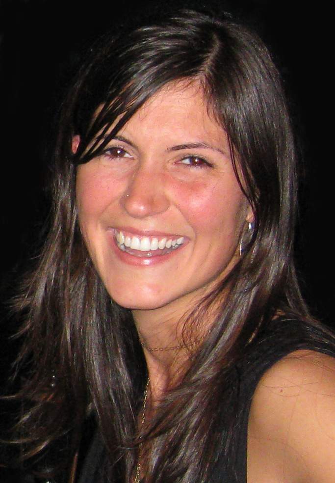 A woman smiling for the camera in a black top.