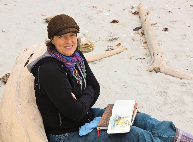 A woman sits on a log while holding a book.