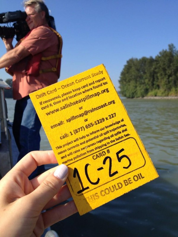A person holding up a yellow ticket on a boat.
