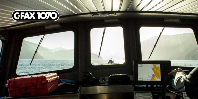 The view of the coast through the front window of a research vessel on the water.