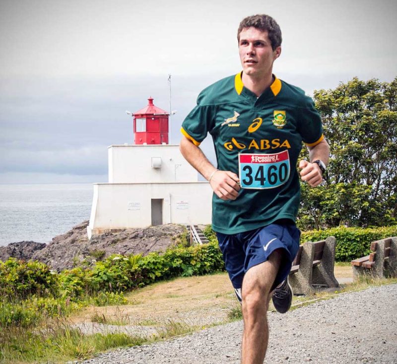Gio runs by a lighthouse, during a Vancouver Island marathon.
