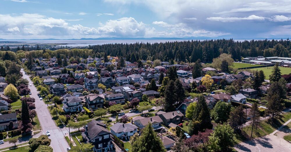 Drone image of a neighbourhood with the Fraser Estuary in the background.