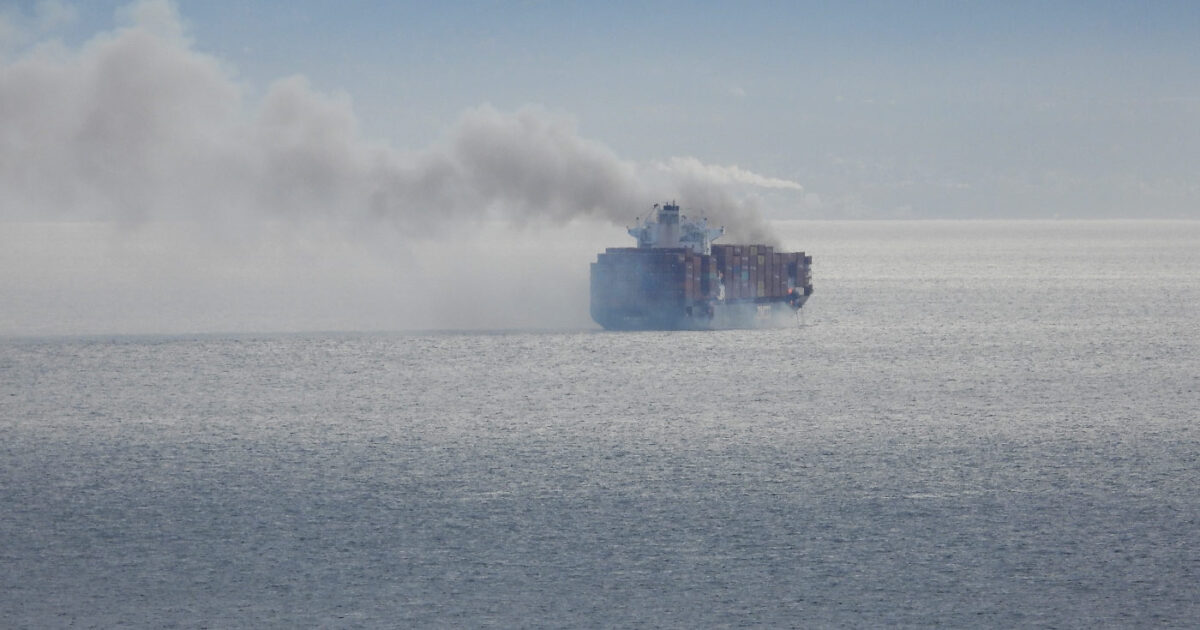 Cargo ship in the ocean on fire.