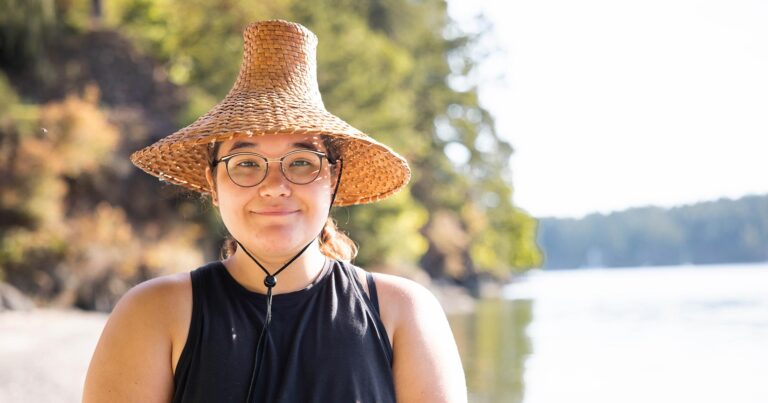 Kaleah Claxton in a cedar hat on a beach