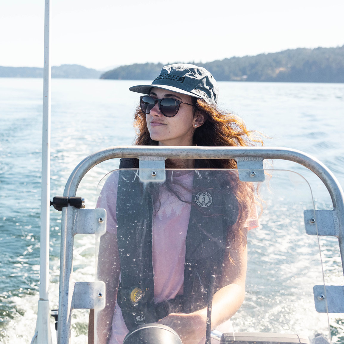 Pascale driving a zodiac boat on a sunny day.