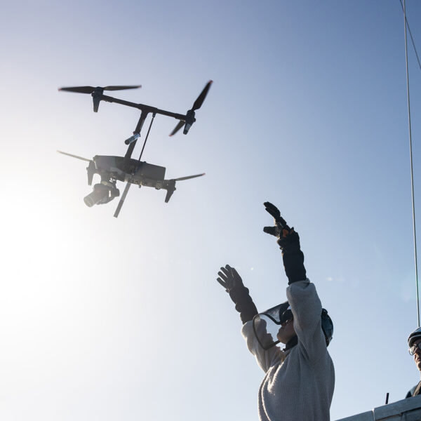 Drone returning to pilots with their hands ready to catch it.