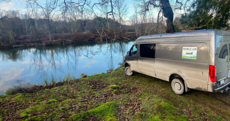 Cargo van next to a river.