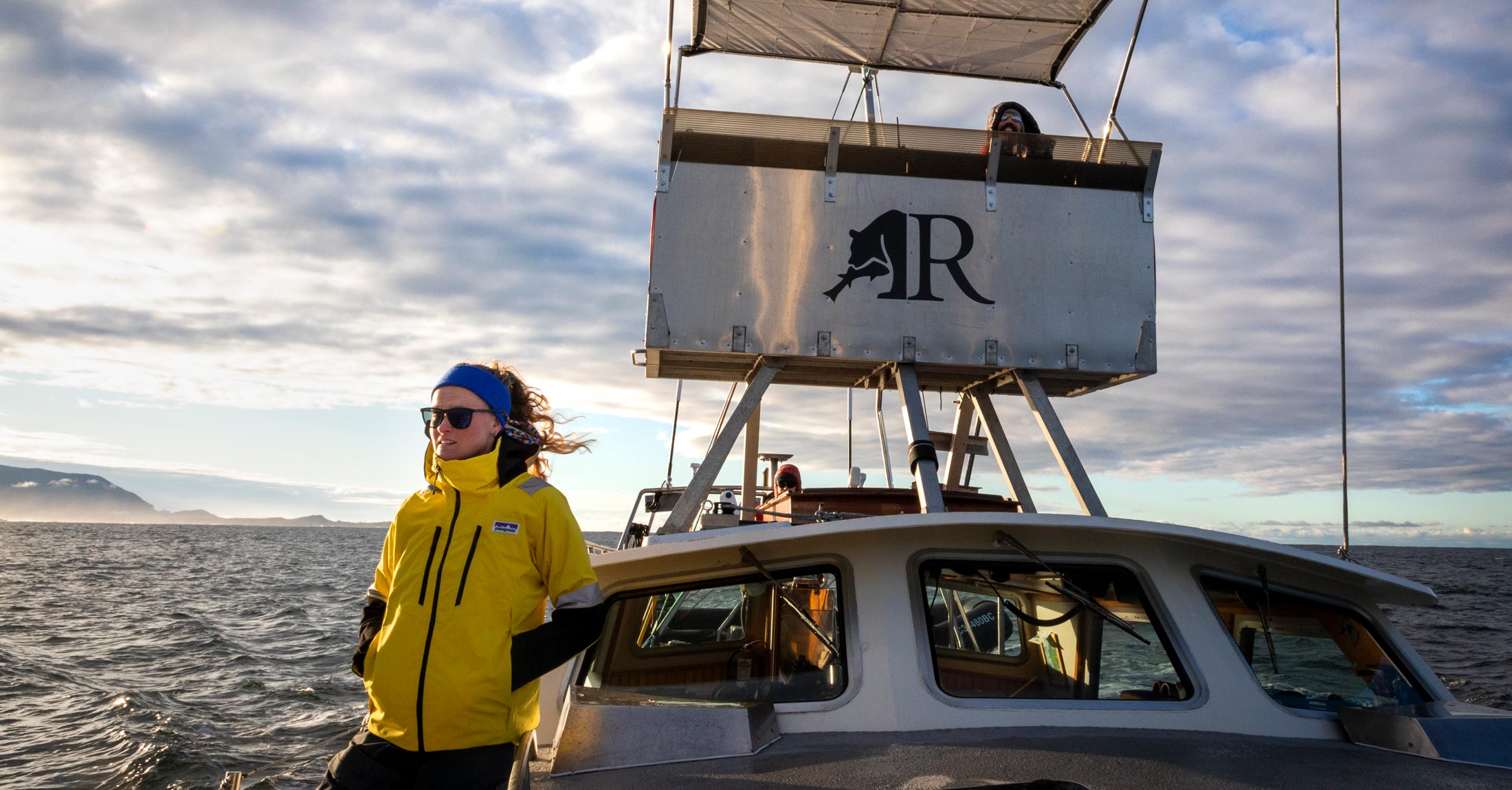 Marlie temple on board Achiever, in the wind, with sunglasses.