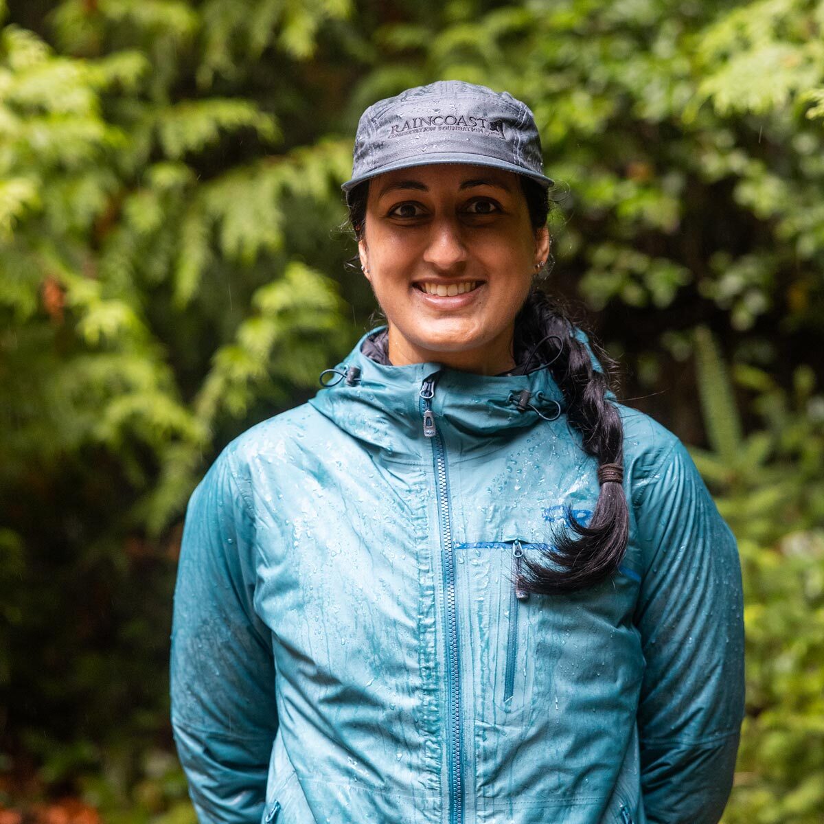 Priya Puri stands in the rainforest in the rain.