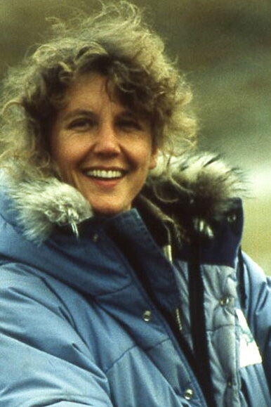 Jane Packard smiling in a blue parka with a hood, circa 1989, on Ellesmere Island, Canada.