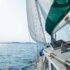 Achiever sails under wind power into a shining bright blue sky sunny day.