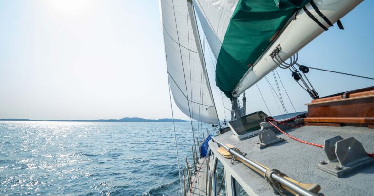 Achiever sails under wind power into a shining bright blue sky sunny day.