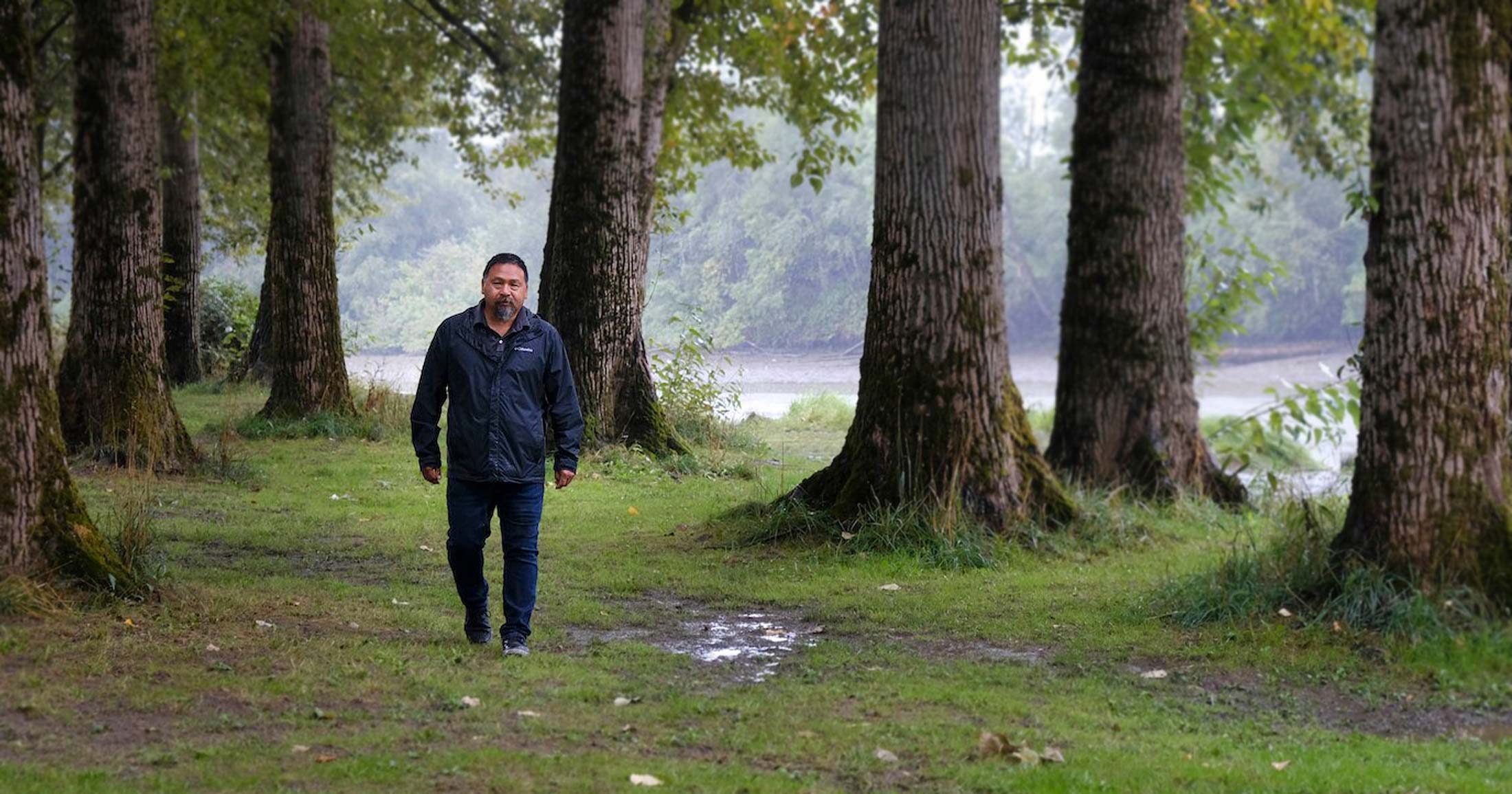 Murray Ned walks along side the Fraser River.