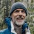 Tom Rutherford stands in the rain with a toque, smiling.