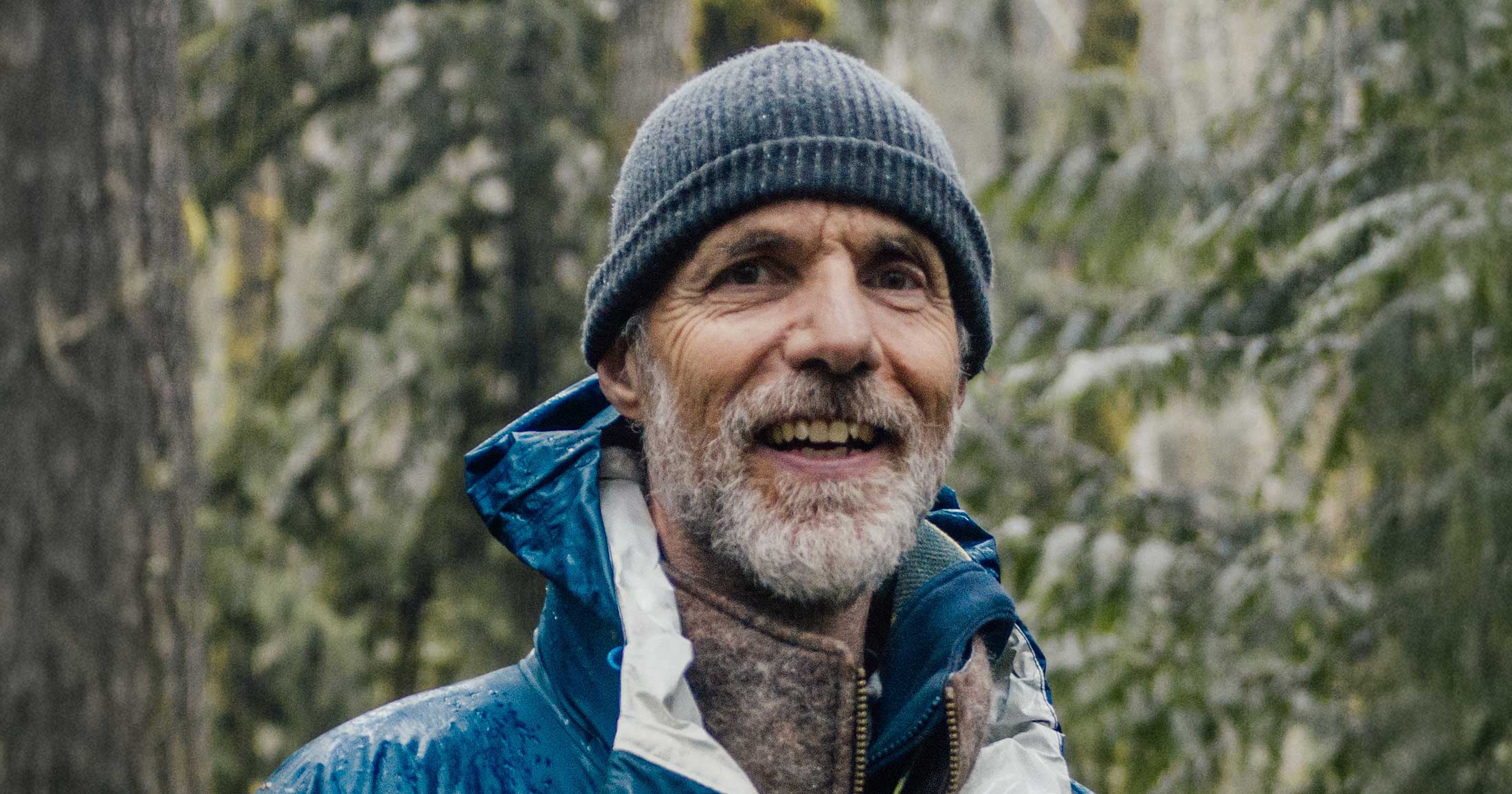 Tom Rutherford stands in the rain with a toque, smiling.