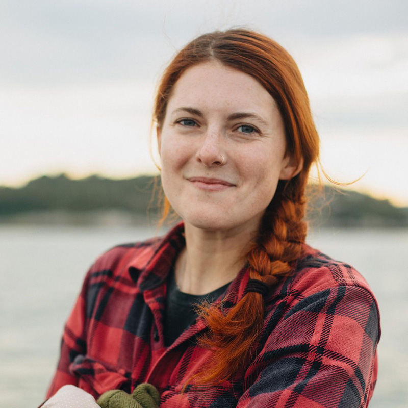 Jaclyn Aubin wears red and black plaid while working on the water.