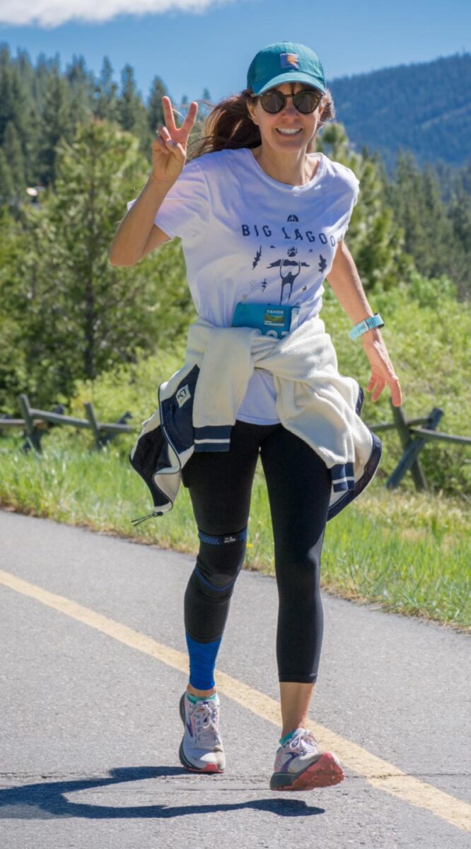 Erica Roper waves for the camera from the highway while running.